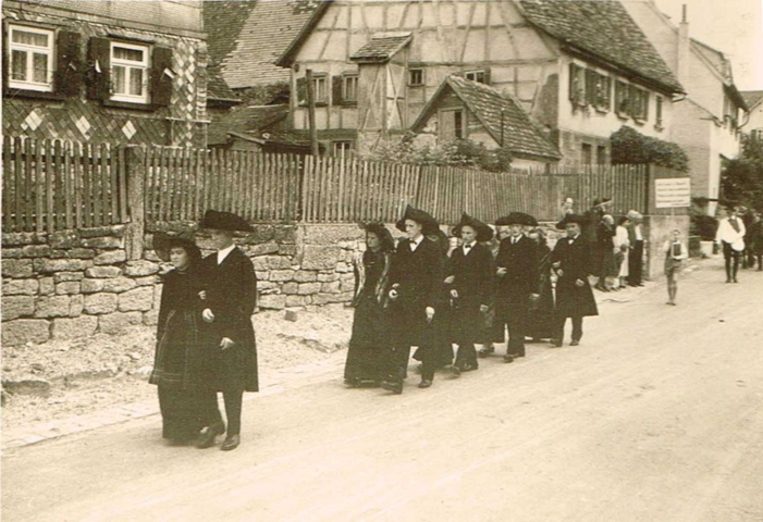 Trachtengruppe auf der Dorfstraße beim Umzug am Heimattag 1957.