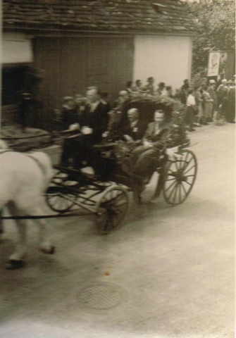 Von Links: unbekannter Kutscher, mit Bürgermeister Gronbach, Pfarrer Günter in der Kutsche beim Heimattag 1957. Im Hintergrund die ehemalige Scheune von Bliesener.
